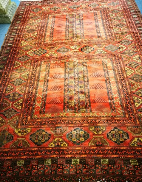 A red ground rug 350 x 248cm
